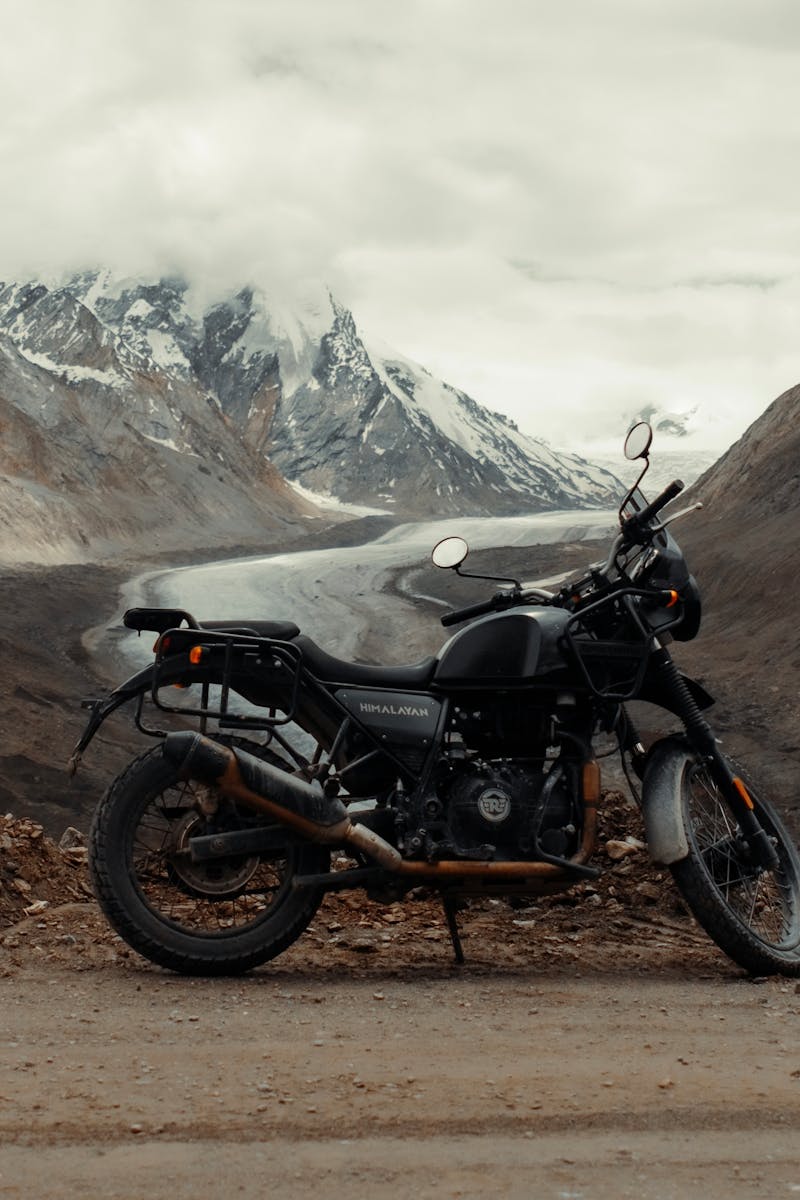 Motorcycle parked on a scenic dirt road in the Himalayas, India, perfect for adventure enthusiasts.