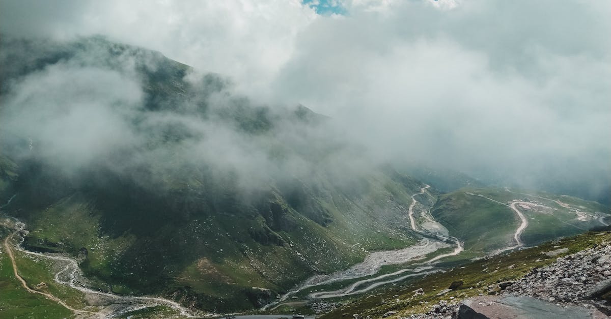 Majestic mountain landscape with clouds and winding trails in Manali, India.