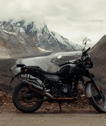 Motorcycle parked on a scenic dirt road in the Himalayas, India, perfect for adventure enthusiasts.