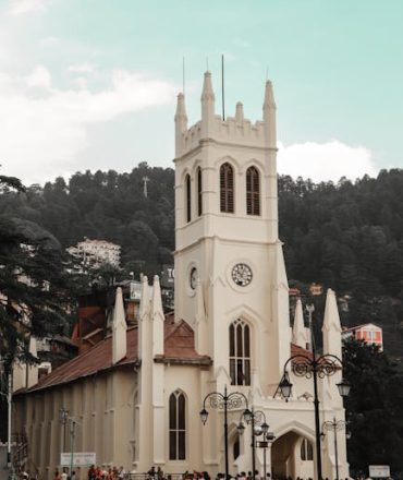 Gothic architecture of Christ Church in Shimla with a bustling crowd and scenic hills in the background.