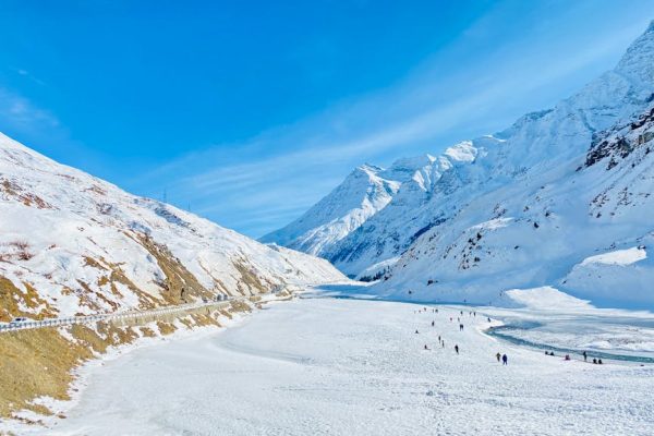 Beautiful winter landscape with snow-covered mountains and a frozen river.